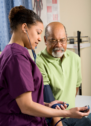 Healthcare provider taking woman's blood pressure.