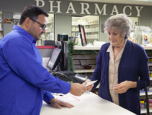 Pharmacist talking with woman about pills.