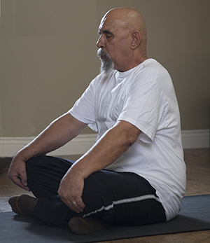 Man sitting in yoga position.