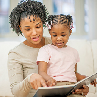 Mother reading her toddler a book about toilet training.